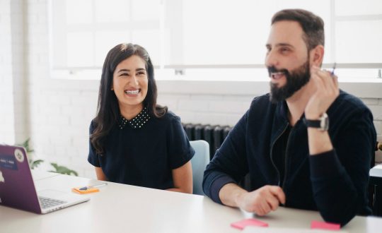A woman and a man are sitting at a table talking