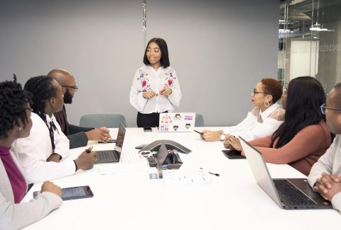 A group of people are siting around a conference table and talking