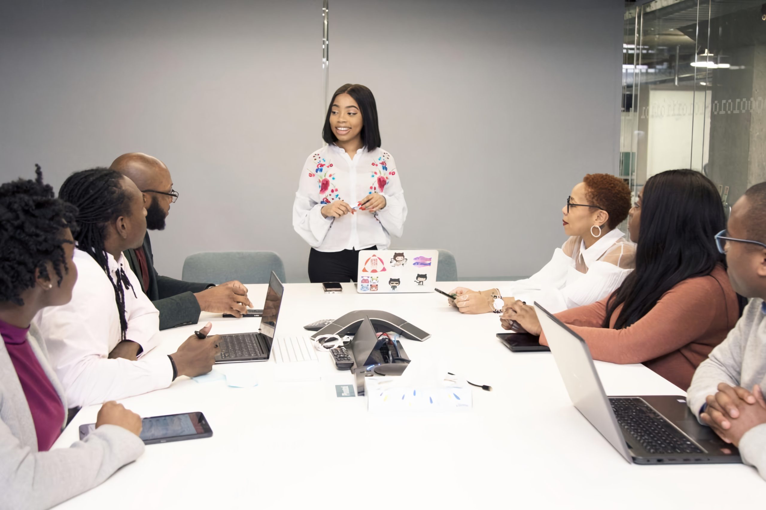 A group of people are siting around a conference table and talking