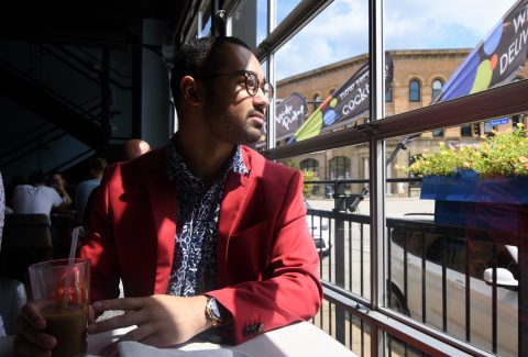 An African american man is sitting and is pondering