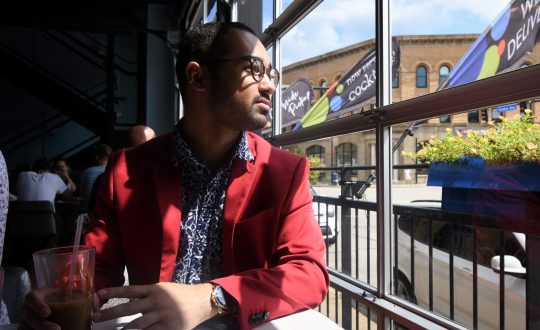 An African american man is sitting and is pondering