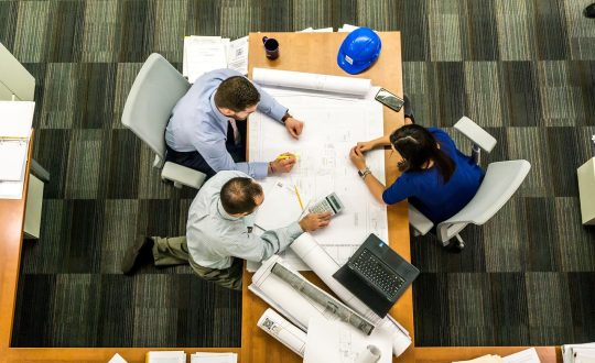 A group of people are sitting at a a table and talking