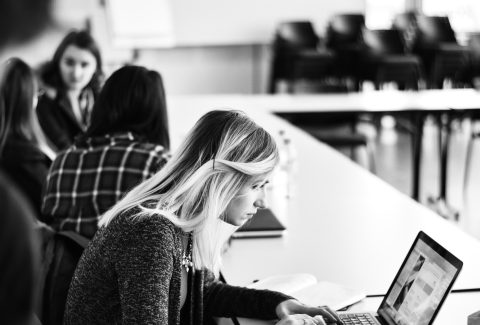 A girl is sitting at a desk reading
