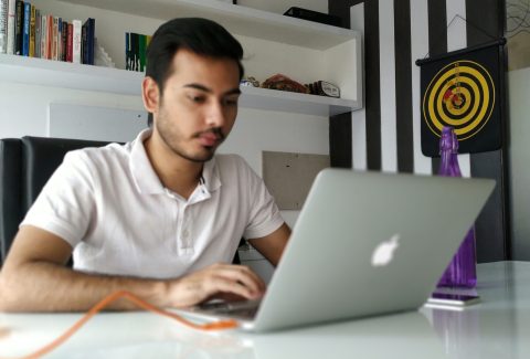 A man ice sitting working on his laptop computer