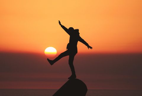 A person is standing on top of a rock outcrop