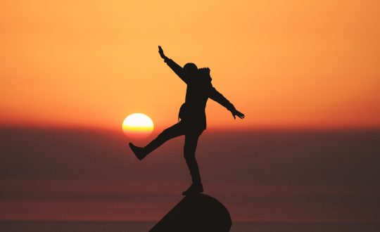 A person is standing on top of a rock outcrop