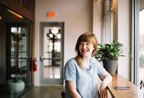 A woman is sitting and looks to be talking to someone