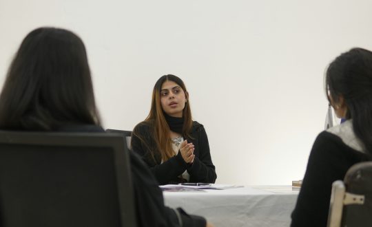 A group of woman are sitting and talking