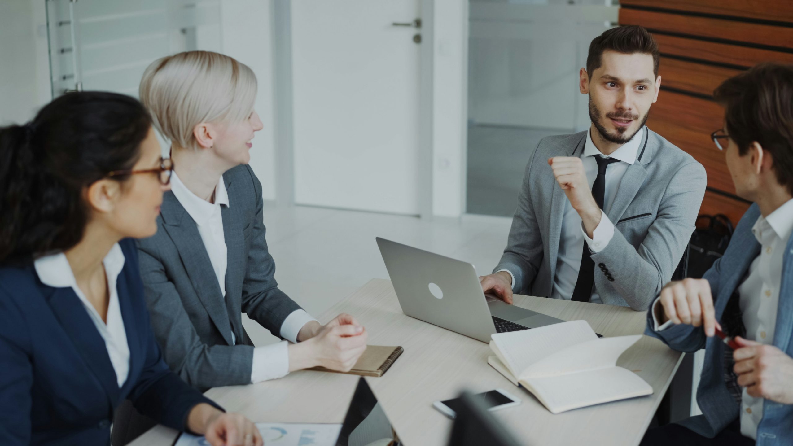 A group of business men and woman are sitting and talking