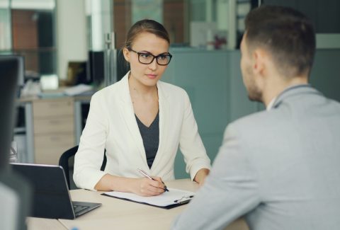 A business man and woman are sitting and talking