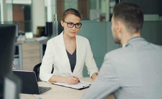 A business man and woman are sitting and talking