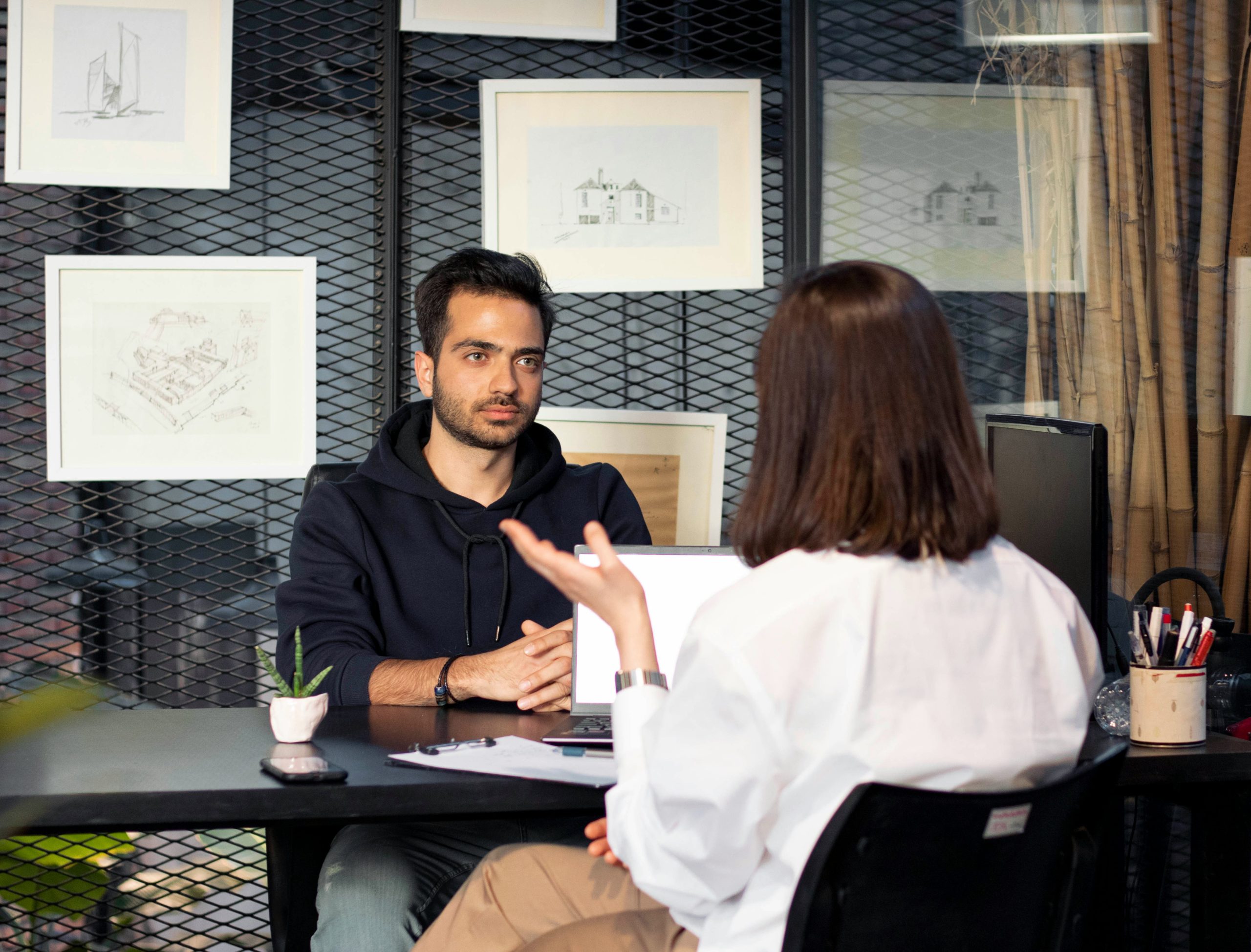 A man and a woman are sitting in an office and talking