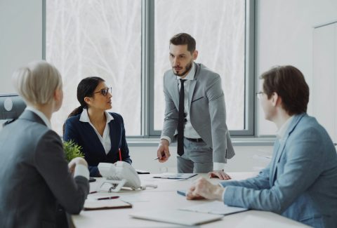 A group of men and woman are in a conference room and talking