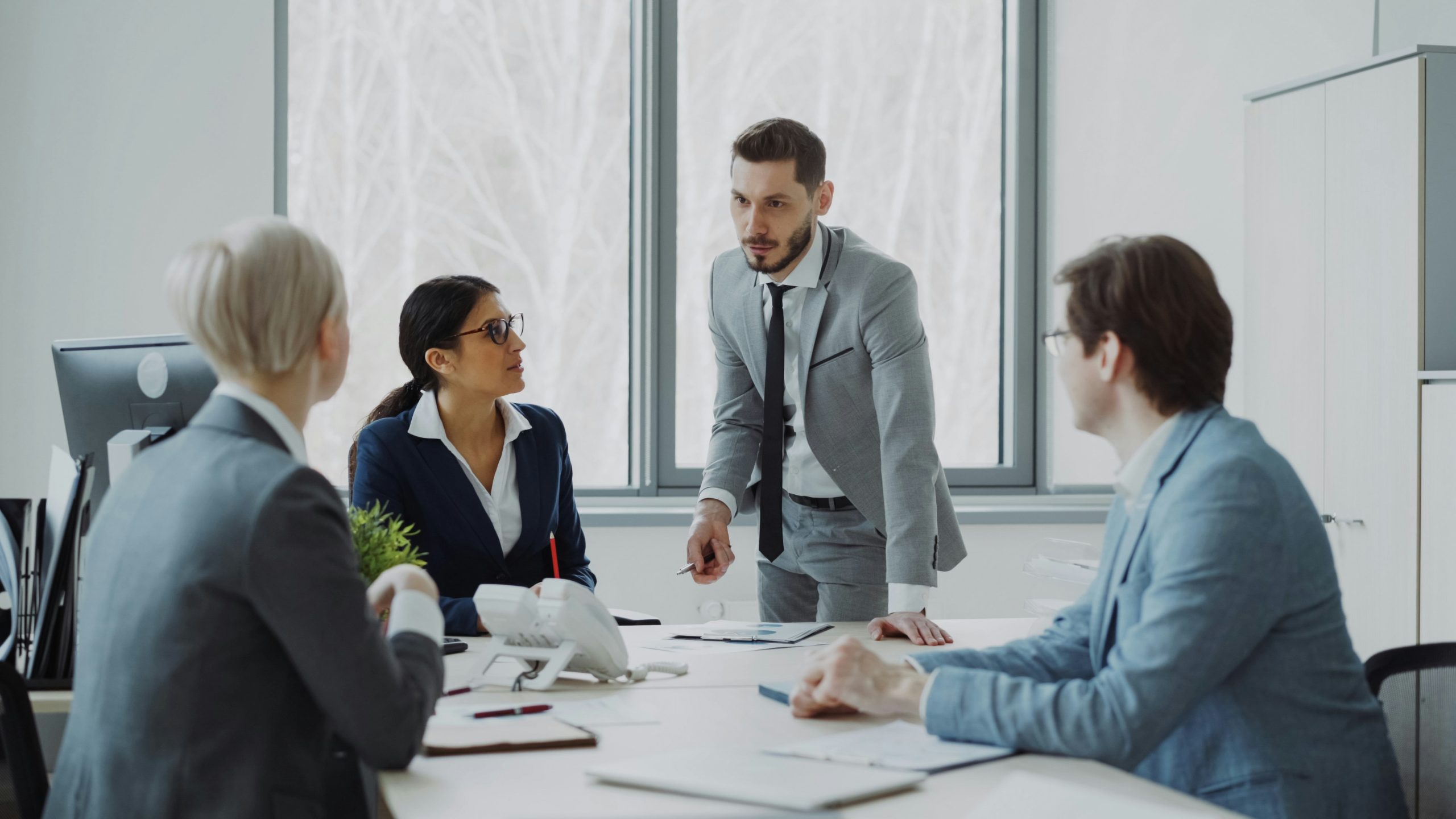 A group of men and woman are in a conference room and talking
